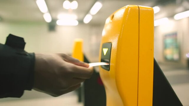 Yellow terminal for control and time stamping on a travel document in public transport. The white hand makes a mark, then the African American hand pays the fare in the same way. Multinational city.