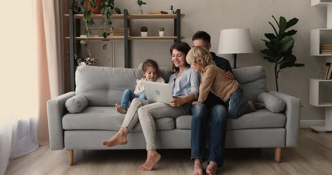 Young Couple With Preschool Son Daughter Resting On Couch Using Laptop Make Video Call, Watch Educational Cartoons For Little Kids, Develop Offspring Use Modern Wireless Tech, Weekend Leisure Concept