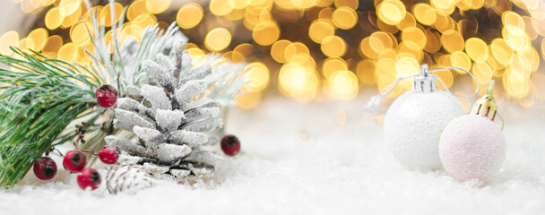Pine cones, berries, Christmas pink balls on the snow. Winter decoration with copy space.