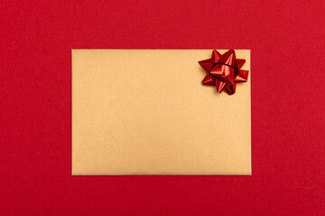 gold envelope with a letter on a red background and with a bow