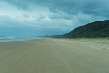 Fototapeta na wymiar vehicle tracks on the beach on a cloudy day