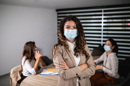 Group Of Three Business People Working Together In Their Office On Important Project. They Wearing Protective Face Masks Against Virus Infection.