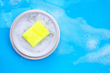 Washing dishes concept on wet blue background. Top view