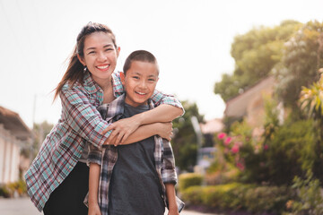 Happy mother hug son or pupil with backpack before they go to school, Back to school concept, Selective focus.