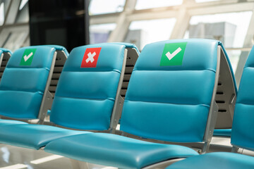 Fototapeta premium Seat on empty with X symbol sticker at airport , social distancing for protect coronavirus or covid-19 virus a new normal trend.