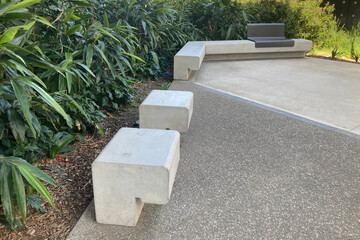 Precast concrete park bench seats with lush garden bed in the background. Ismay reserve metal and...