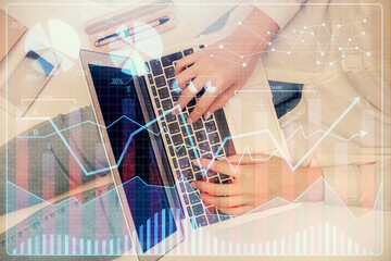 Double exposure of woman hands working on computer and forex graph hologram drawing. Top View. Financial analysis concept.