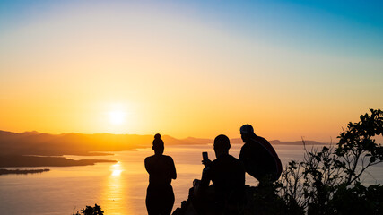 Fototapeta na wymiar Groupe d'amis observant le lever de soleil sur la côte sud de la Martinique.