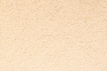 Texture of a light yellow wall. Decorative plaster.  Rough grainy bumpy surface. Perfect for background and design. Closeup.