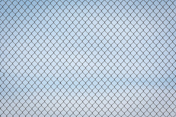 Fototapeta premium Chain Link Fence against a Cloudy Blue Sky