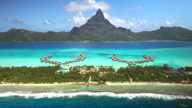 4k drone Bora Bora Tahiti. Aerial view of overwater bungalow villas in blue lagoon. French Polynesia. Exotic travel vacation getaway, romantic honeymoon destination.