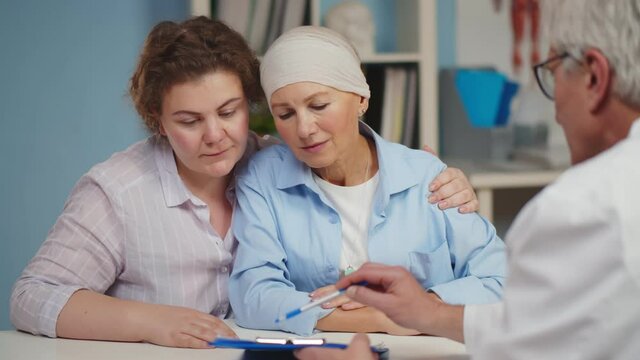 Senior cancer woman with daughter visiting doctor in hospital