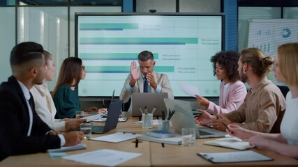 Chief executive male talking with colleagues about financial success in office