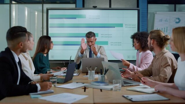 Chief executive male talking with colleagues about financial success in office