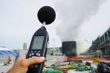 Hand of Environmental officer holding to use sound level meter for monitor is part of the...