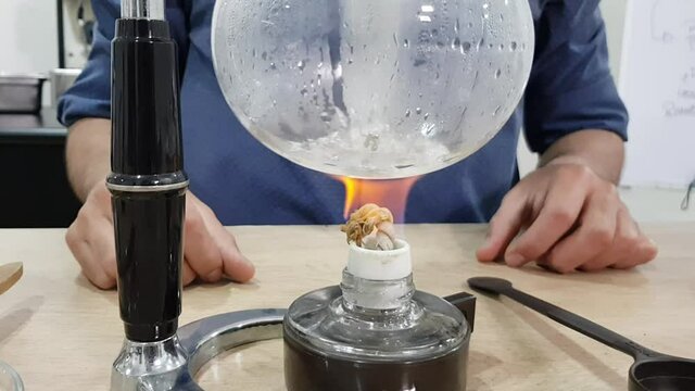 Barista making syphon coffee, syphon coffee is a new way to brew third generation americano