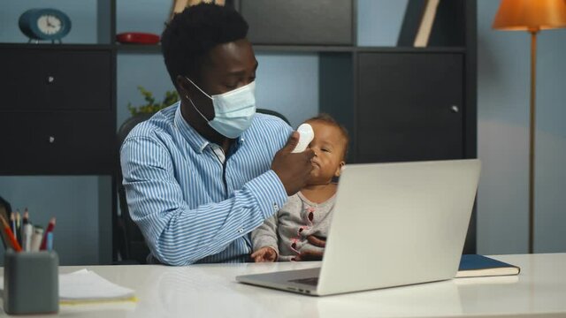 Father In Mask Measuring Temperature To Cute Sick Baby Consulting Doctor Online