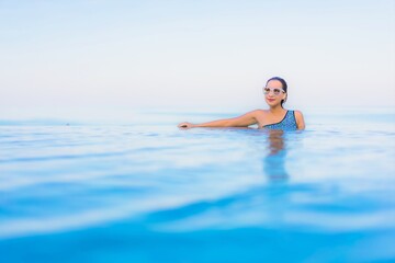 Portrait beautiful young asian woman relax smile leisure around outdoor swimming pool nearly sea