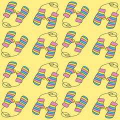 Pattern of cute knitted mittens on a yellow background. Warm striped mittens for protection from the cold. Autumn and winter clothing. Background for fabric, cover art, banners, and web design.