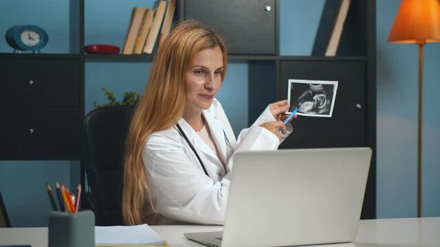 Female doctor gynecologist working in clinic consulting patient online