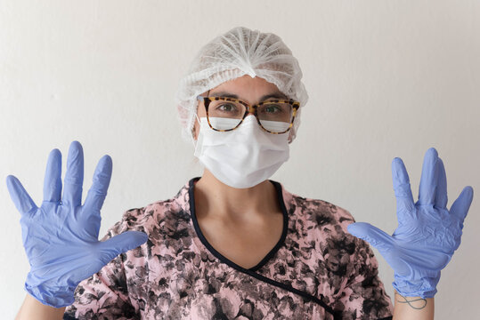retrato de enfermera, con elementos de bioseguridad por covid 19, saludando en lenguaje de señas. 