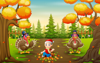 Little boy and turkeys bird playing with fallen leaves