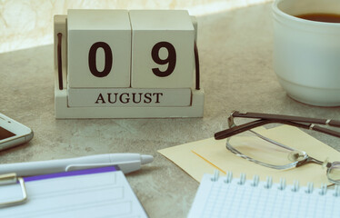 August 09, date on the calendar. Handmade wood cube with date month and day. planning for the day. artistic coloring. selective focus.