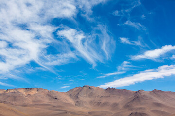 Off-road vehicle driving in the Atacama desert, Bolivia with majestic colored mountains and blue...