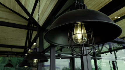 Incandescent lamp shining in cafe restaurent, Yellow light of lamp hang on ceiling