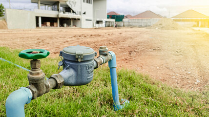 Water meter on concrete with home and green nature background, Water meter for supply consumption mesurement of home plumbing system, water sewer sanitary flow counter valve