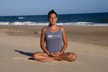 Fototapeta na wymiar Young girl meditating on the beach