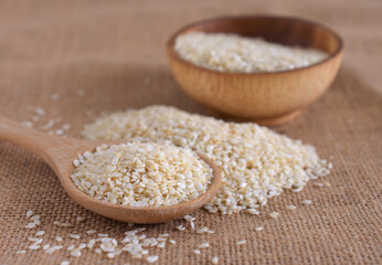 White sesame in a wooden spoon,copy space.