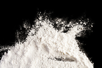 Obraz na płótnie Canvas Flour on a colored background. A pile of flour on a white background. Spilled flour. Flour texture