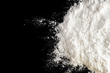 Flour on a colored background. A pile of flour on a white background. Spilled flour. Flour texture