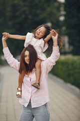 Beautiful family in a park. Woman in a blouse. Mother with daughter.