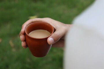 ands holding hot cup of coffee or tea