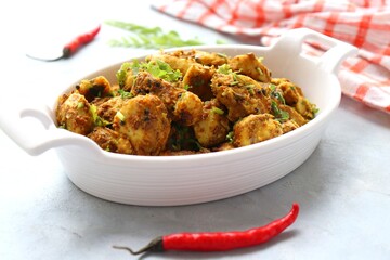 Stir fried taro roots. Arbi ki sabji, Taro roots masala curry. Arbi Masala. Garnished with coriander, red chili & curry leaves. copy space.