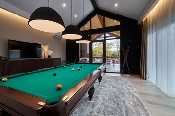 modern billiard room with a beautiful table and large windows