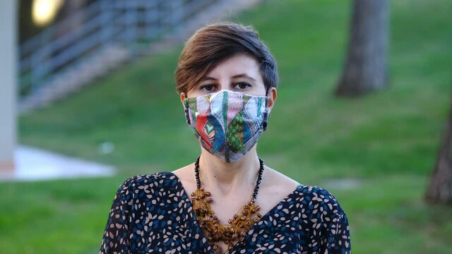 pandemic 2020 - young woman wearing the mask sighs staring at camera