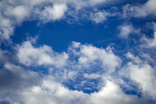 Cumulus clouds fill the picture, swelling cloud against a beautiful blue sky.