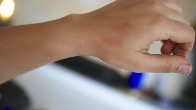 Woman gently applying blush on the back of her hand