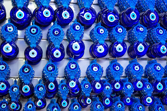 Various blue amulets evil eye beads nazar boncugu Hanging on the white colored wall background in antalya turkey