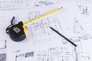 Hand over construction plans with yellow helmet. laptop and drawing tool