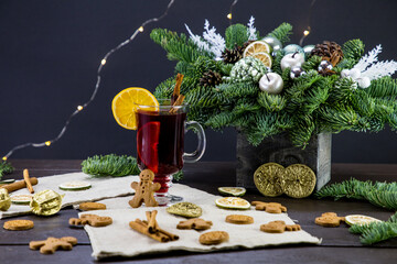 winter treats, a mug of warm wine with an orange, and cookies, ingredients on a wooden brown table....