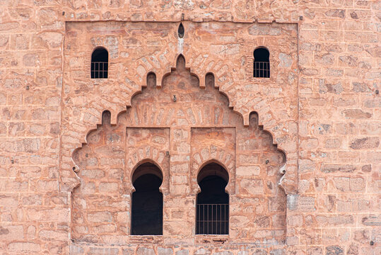 Ancient walls of medina in Marrakech, part of Kutubiyya mosque, arabian style of doors and windows, buildings by red clay, Morocco