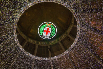 Milan, Italy - December 22, 2019 Galleria Vittorio Emanuele, evocative image of the center of the gallery illuminated with the city coat of arms and Christmas decorations
