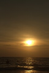father and son swimming in the sea under beautiful sunset in Port Dickson beach Malaysia
