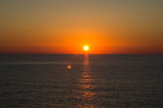 evocative image of sunrise over the sea with the sun rising on the horizon
