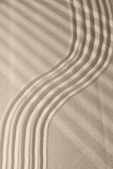 Fototapeta na wymiar Sand surface texture with smooth lines and shadows, for relaxation and spiritual harmony