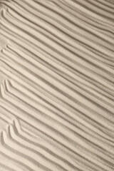 Fototapeta na wymiar Sand surface texture with smooth lines and shadows, for relaxation and spiritual harmony